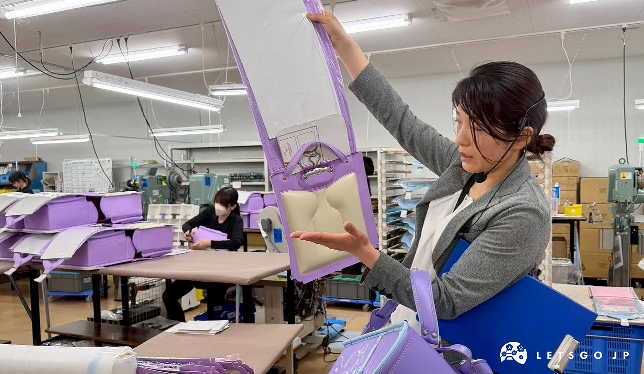 導覽人員在工廠內介紹日本小學生書包製作流程。