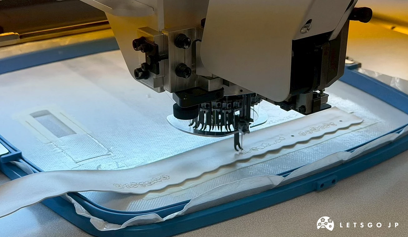 刺繡機正在藍色書包布料上繡製圖案,多支刺繡針同步運作,在布料表面縫出細緻的刺繡紋樣