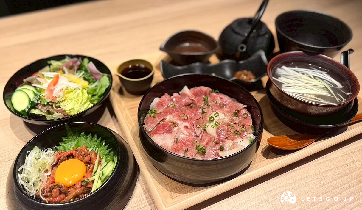 桌面上鋪滿的豪華牛肉料理盛宴,包含色彩繽紛的生牛肉佐蛋黃碗、炙燒牛肉蓋飯、新鮮生菜沙拉與各式日式佐料。