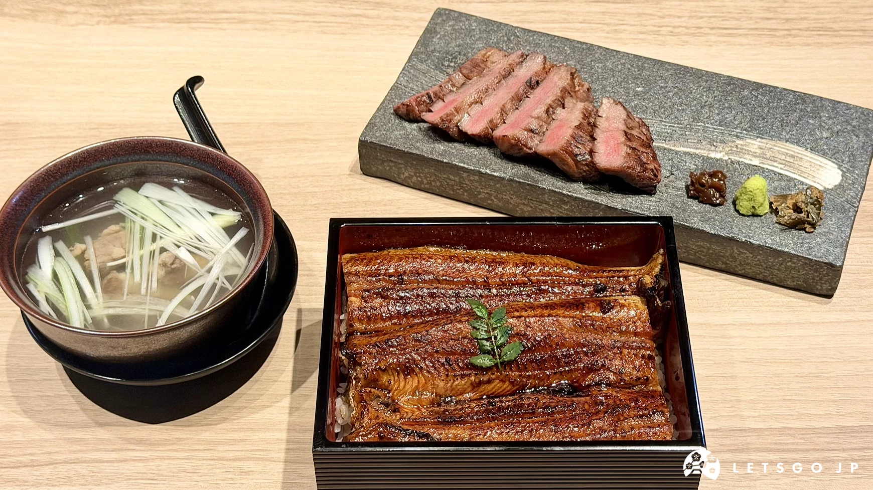 豪華的鰻魚重御膳套餐,包含表面烤至金黃微焦、刷上濃郁醬汁的蒲燒鰻魚飯,搭配一碗清澈的牛尾湯與一盤色澤粉嫩、整齊排列的炭烤厚切牛舌。