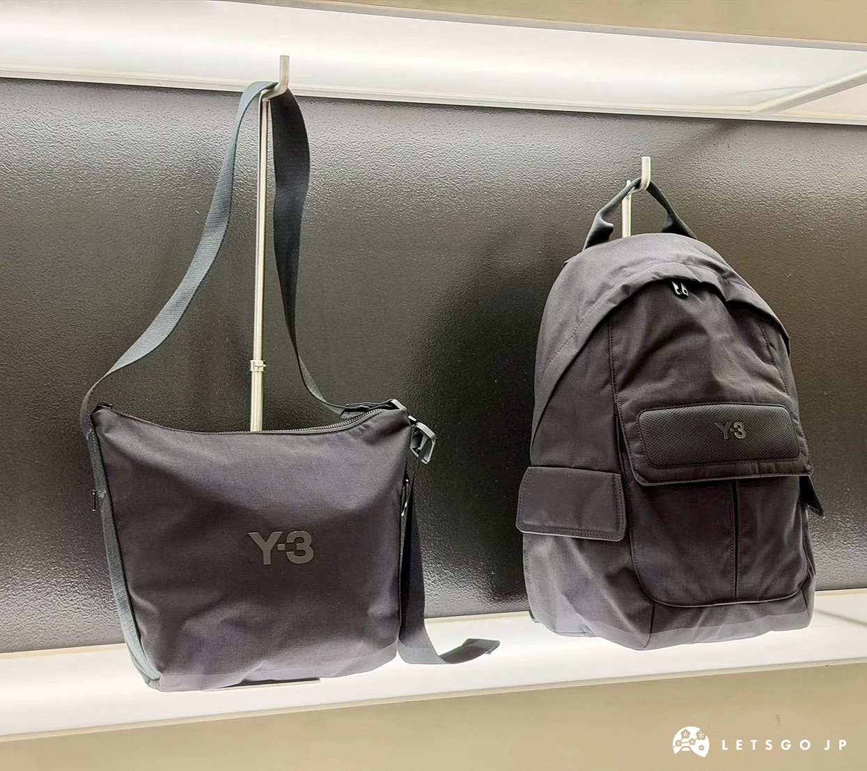 陈列在柜位上的 Y-3 黑色斜背包与黑色双肩后背包。