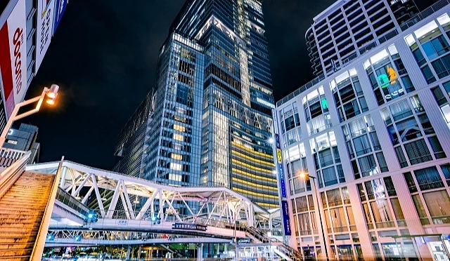 夜間拍攝,右邊有打燈的百貨公司,中間有打燈的天橋