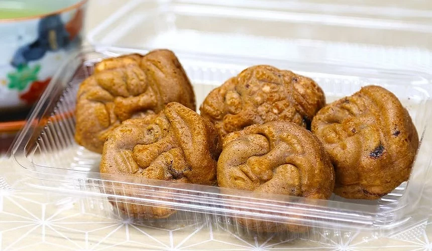5塊人臉形狀的人形燒,放在塑膠盒裡