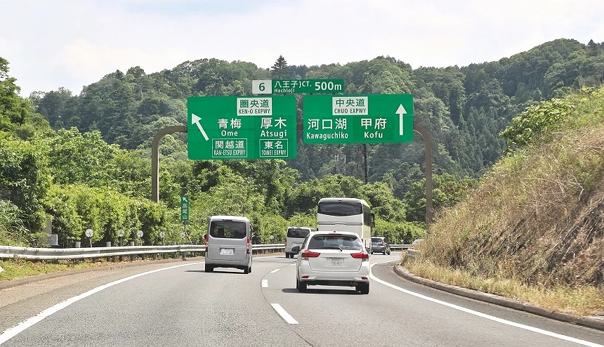 行驶往河口湖国道道路上的自驾租车与前方山景