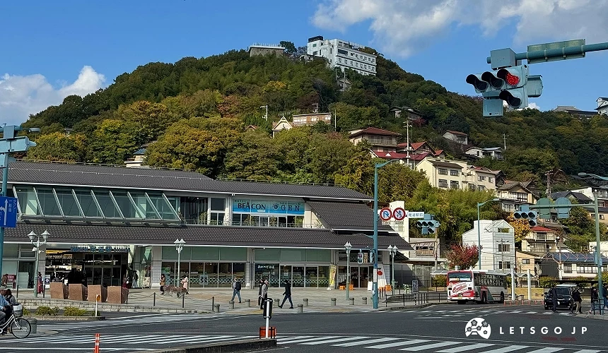 JR 尾道站外观,背后可见千光寺山,车站前设有广场与公车站。