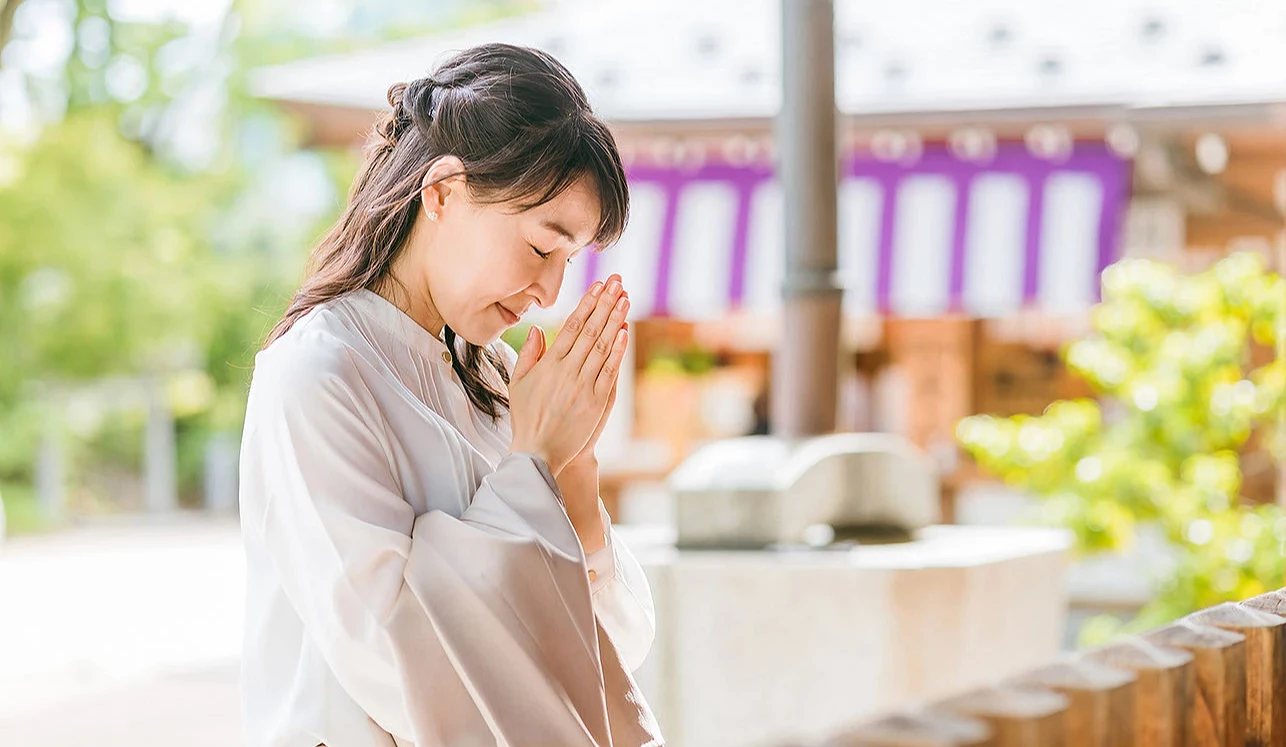 一位女性在神社參拜並合掌