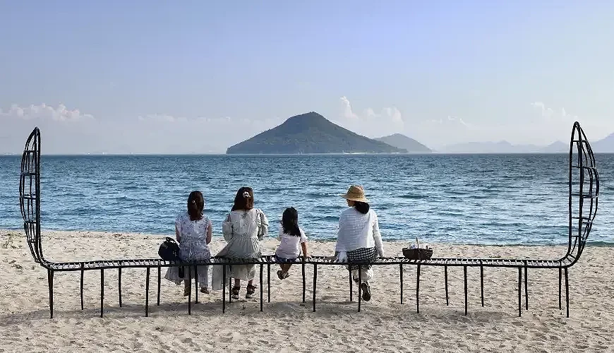 海滩上的行动艺术作品「海を梦见る人々の场所」与坐在上面的观光客们