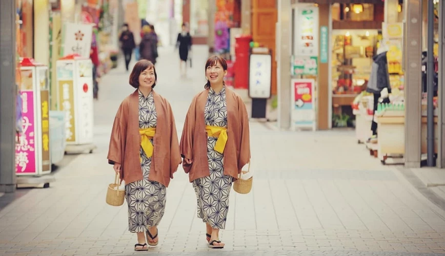 穿着浴衣的旅人在道后温泉时髦商店街散步